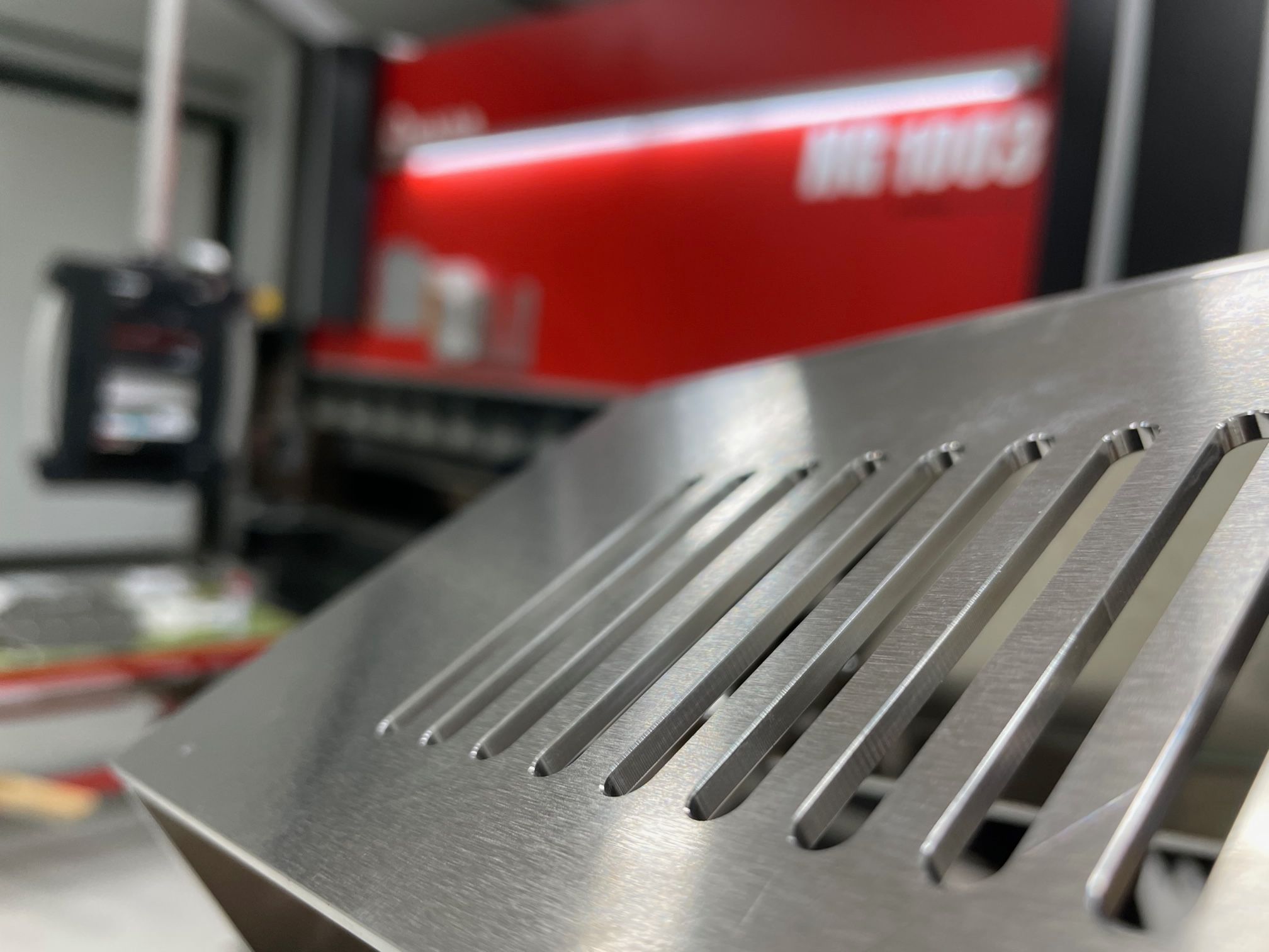 Bearbetad aluminiumplåt framför Amada-kantpressen